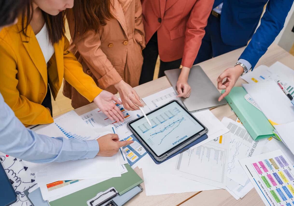 Business meeting showcases agile brainstorming with data analysis charts on tablets. Financial growth prediction strategy through predictive analytics and data-driven insights for strategic business